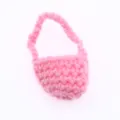 Dettaglio in primo piano di una mini borsa di lana rosa lavorata, accessorio per bambola BJD. - Rosa
