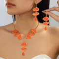 Detailed close-up of orange enamel pebble gold-tone necklace and earrings jewelry set. - 2-Piece Necklace & Earrings Set / Orange