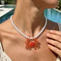 Gros plan détaillé du collier de perles style vacances d'été avec pendentif crabe rouge vif. - Style Crabe Rouge Perles Blanches Artificielles (JMX-XL9510)