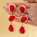 Vue détaillée de longues boucles d'oreilles pendantes en résine rose irrégulière dorée. - Rouge Rose Irrégulier Pendant / Rouge Rose (JMX-ER9656)