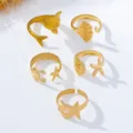 Vista detallada de anillos abiertos dorados con temática marina y detalles de conchas. - Juego de Anillos de Dedo del Pie Serie Océano (JMX-JZ9514) / Set de 5 piezas