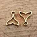 Goldener hohler Walfischschwanz Anhänger Detailansicht, ideal für DIY Schmuckherstellung. - Altgold