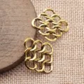 Nahaufnahme von hohlen geometrischen rautenfoermigen Anhaengerverbindern fuer Schmuck. - Altgold