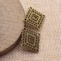 Detailaufnahme der bronzenen hohlen rautenförmigen Schmuckverbinder für kreative DIY Projekte. - Altgold