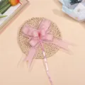Gros plan détaillé du nœud en tulle rose élégant pour décoration de mariage. - Rose d'eau