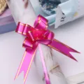 Detail view of a medium hot pink gift pull bow with gold edge for flower wrapping. - Rose Red Gold Edge