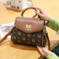 Elegante borsa a mano da donna in pelle marrone con stampa monogramma e comoda tracolla. - Stile M / Giallo ocra