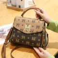 Borsa a tracolla marrone con monogramma, chiusura in metallo e motivo elegante per donna. - Stile M / Kaki
