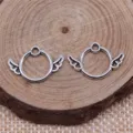Close-up of antique silver round wing pendants, perfect DIY jewelry making accessories. - Antique Silver