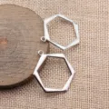 Detailansicht silberner, hohler, geometrischer Sechseck-Metallanhänger, ideal für DIY-Schmuck. - Weißgold
