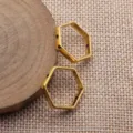 Geometrischer hohler Sechskant-Schmuckverbinder, Nahaufnahme zeigt metallische Textur. - Altgold