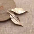 Nahaufnahme von goldenen Blatt-Anhänger-Details, ideal für kreatives DIY-Schmuckdesign. - KC Gold