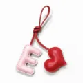 Detailed close-up shot of the pink leather letter E and red heart bag charm pendant. - Light Pink with Bright Red Heart