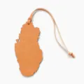 Gros plan détaillé du charm de sac en cuir en forme de carte avec une texture fine et lanière. - Orange