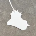 Detailed view of white leather Iraq map bag charm, showing fine texture and strap. - White
