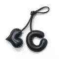 Vista de primer plano de detalle de colgante de bolso letra C de cuero negro y corazón. - Negro con Corazón Negro