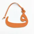 Primer plano detallado de colgante de bolso de cuero naranja con letra árabe accesorio. - Naranja