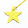 Détail de pendentif sac étoile cuir jaune, accessoire texturé avec lanière pour sac à main femme. - Jaune