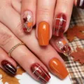 Close-up view of autumn press-on nails featuring maple leaf glitter, plaid, and caramel. - Autumn Maple Leaf Plaid Style (YS359) / 24 Pcs/Set