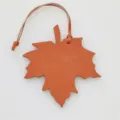 Orange leather maple leaf bag charm and car pendant with fine hanging strap accessory. - Orange