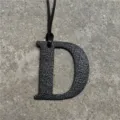Black textured leather letter D bag charm with leather cord, stylish accessory pendant. - Black