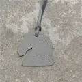 Vue détaillée d'un mini charm's de sac tête de cheval en cuir gris avec fine texture. - Gris