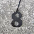 Black leather texture number 8 bag charm pendant detail shot, stylish DIY accessory decor. - Black