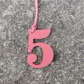 Gros plan détail pendentif chiffre 5 en cuir rose, accessoire sac DIY mignon et chic. - Rose
