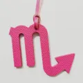 Schorpioen dierenriem leer hanger detail met getextureerde roze tas charm close-up view. - Rozerood