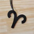 Detailed shot of black leather Aries zodiac sign bag charm showing fine texture and shape. - Black