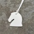 Détail de breloque de sac tête de cheval en cuir blanc, design épuré avec lanière assortie. - Blanc