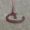 Detailed shot of a burgundy leather Arabic letter bag charm pendant with a strap. - Burgundy