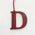 Burgundy leather letter D bag charm with hanging strap, elegant luxury style accessory. - Burgundy