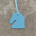 Mini charm's de sac tête de cheval en cuir bleu clair, gros plan du pendentif texturé. - Bleu ciel