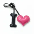 Detailed shot of the leather letter I and pink heart bag charm, showing fine stitching. - Black with Rose Red Heart