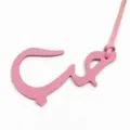 Gros plan du charm de sac en cuir rose représentant une lettre arabe avec texture fine et lanière. - Rose