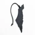 Detailed view of a black leather map shape bag charm and pendant accessory for stylish bags. - Black