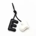 Leather letter E heart bag charm detail, black and white handmade stitching pendant close up. - Black with Off-white Heart