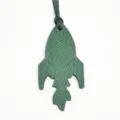 Dettaglio ciondolo borsa razzo in pelle verde, elegante portachiavi e accessorio borsa. - Verde Scuro