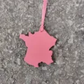 Pink leather France map bag charm and car hanging ornament detail view showing shape and texture. - Pink