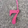 Dettaglio ciondolo borsa numero 7 in pelle rosa, elegante accessorio fai da te con cinturino. - Rosso rosa