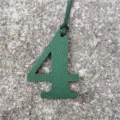 Green leather number 4 bag charm pendant DIY accessory detail shot showcasing texture and design. - Dark Green