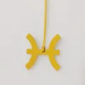 Detail van de gele leren tassenhanger in de vorm van het astrologische teken Vissen en riem. - Geel
