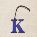 Détail de charm de sac lettre K en cuir bleu, accessoire élégant pour sac à main monogramme. - Bleu saphir