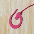 Vue détaillée du charm de sac en cuir rose avec une texture fine et une belle finition soignée. - Rose rouge