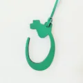 Green leather Arabic letter bag charm detail showcasing textured surface and edge paint finish. - Green