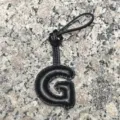 Detailed view of the black leather letter G bag charm featuring soft puff texture and loop. - Uppercase Letter G / Black