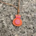 Detailed view of handmade leather lucky bag pendant, candy color keychain and bag charm. - Orange