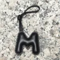 Black leather letter M bag charm detail view, chic initial pendant for purses and keys. - Uppercase Letter M / Black