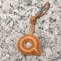 Close-up detail of the stylish brown leather letter Q bag charm and pendant accessory. - Letter Q / Tan